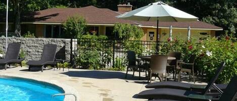 A swimming pool with lounge chairs and a patio area.