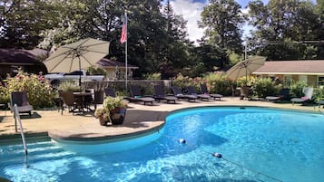 Relax by the serene pool surrounded by lush greenery and comfortable lounge seating.