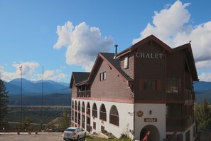 A chalet with a balcony, arched windows, and a sign reading "lobby".