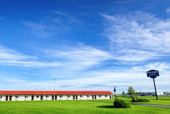 Ein Motel mit rotem Dach und einem Schild mit der Aufschrift "Northern Lights Inns & Suites".