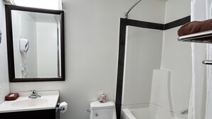 A modern bathroom with a white sink, toilet, and bathtub. - Northern Lights Inn & Suites (Valleyview)