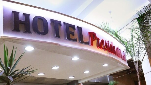 Een hotelentree met een bord waarop 