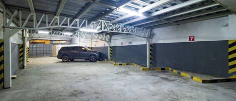A multi-level parking garage with concrete floors and metal beams.