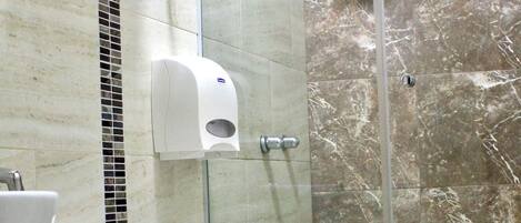 Un baño con inodoro, lavabo y ducha.