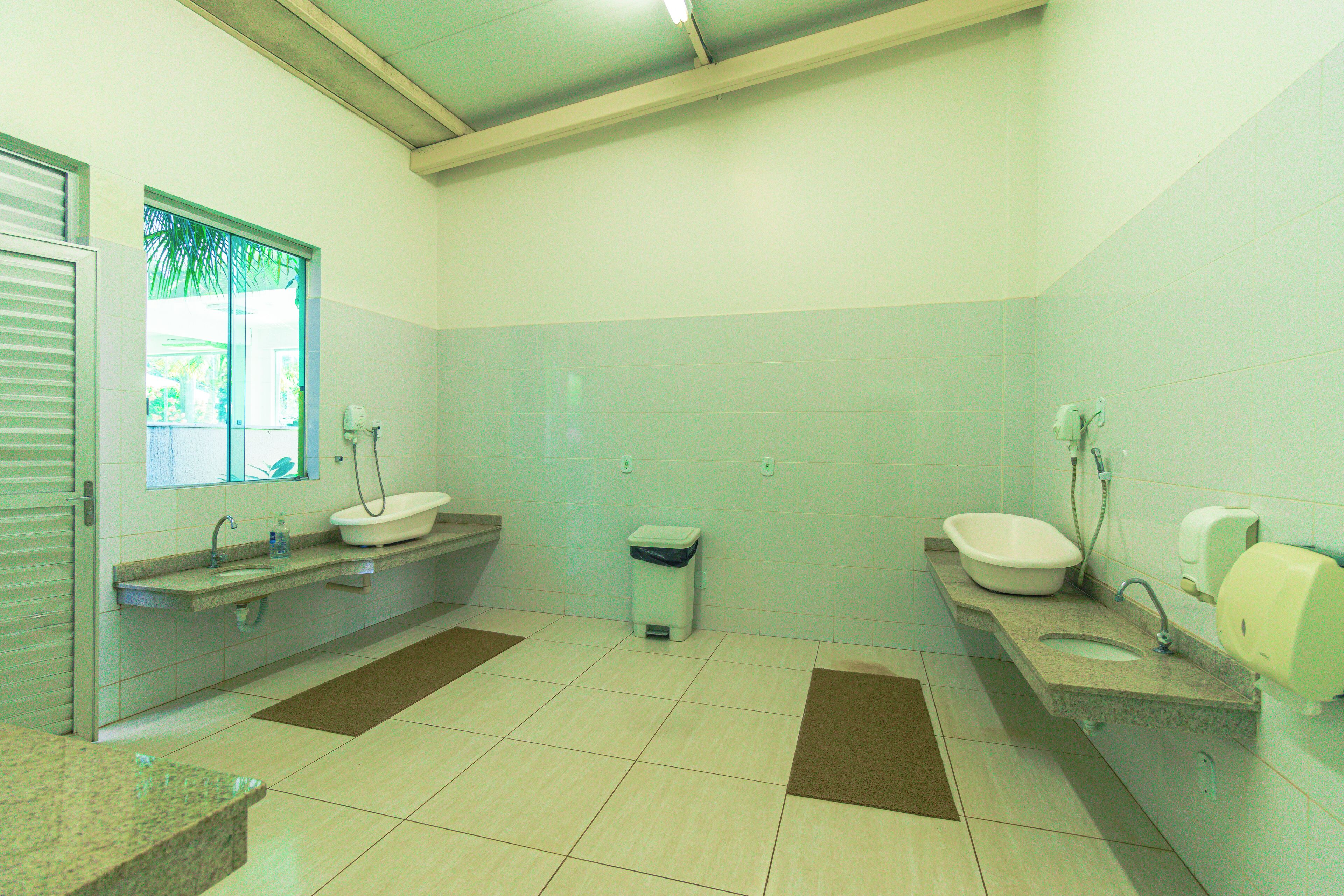 A bathroom with a sink, toilet, and window.