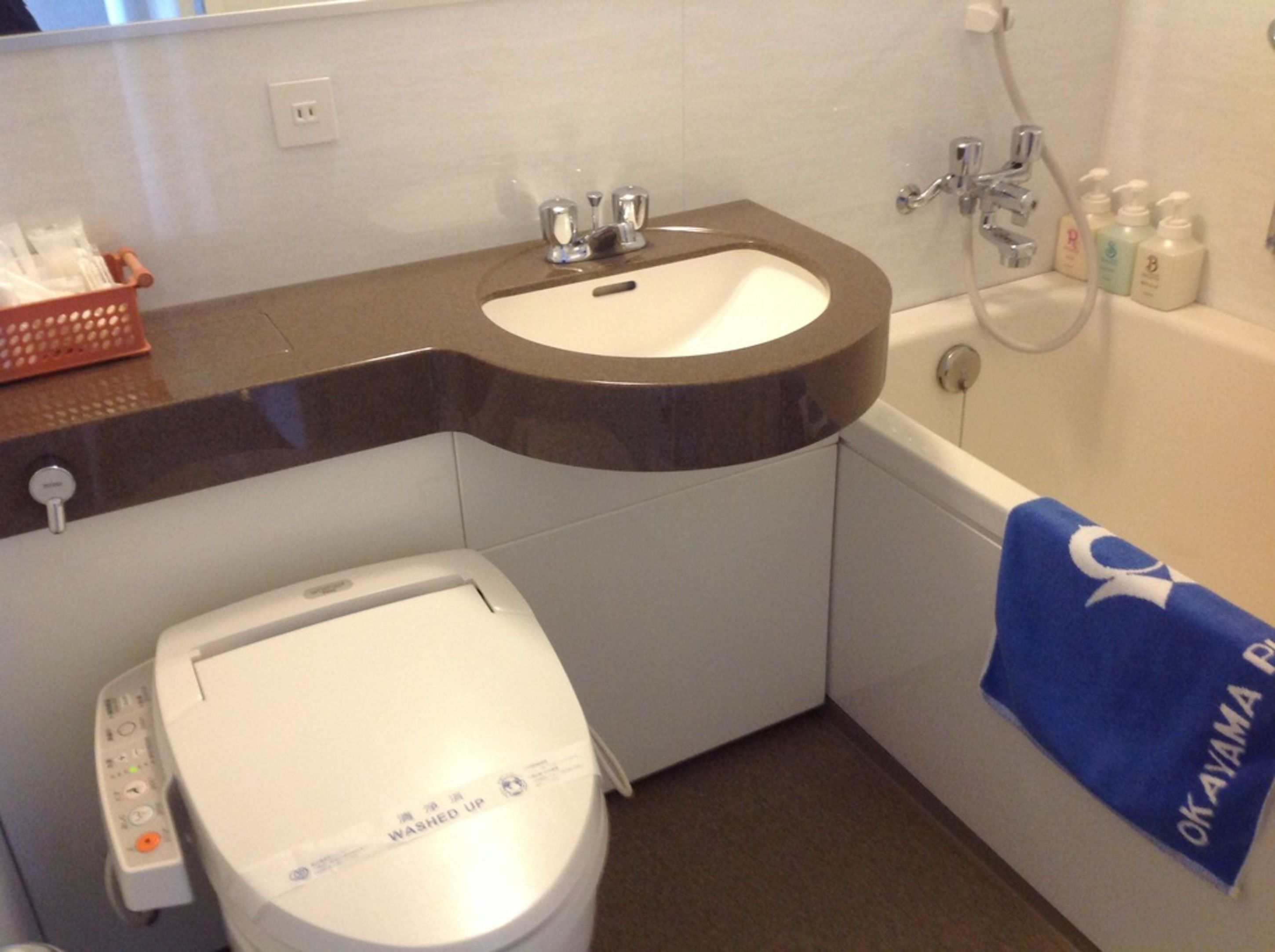 A bathroom with a white toilet, a sink, and a bathtub.