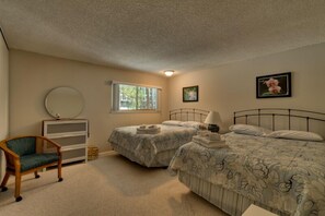 A bedroom with two beds, a chair, a dresser, and a window. - 1200 Wildwood Unit 16 (South Lake Tahoe)