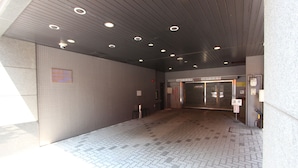 A spacious indoor area with a tiled floor, a ceiling with recessed lighting, and a door leading to another room. - HOTEL LiVEMAX Sapporo-Ekimae (Sapporo)