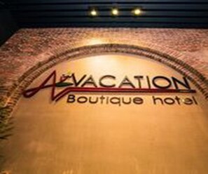 A sign for 'AVACATION Boutique hotel' with a curved arch design. - Vacation Boutique Hotel (Phnom Penh)