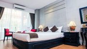 Een moderne hotelkamer met een groot bed, een nachtkastje met lamp en een stoel.