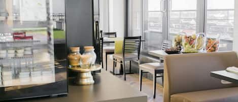 Un comedor moderno con una vitrina de vidrio, un sofá y una mesa con fruta.