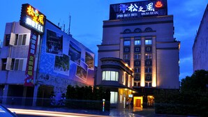 A hotel with a prominent sign, a large window display, and a well-lit entrance. - Spring Breeze Motel (Hualien City)