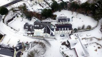 Une vue aérienne d’un quartier résidentiel avec de nombreuses maisons, une route sinueuse et un petit parc.