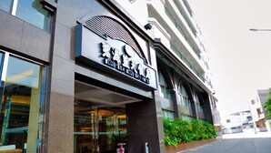 Um hotel com fachada moderna, amplas janelas e uma placa de destaque.