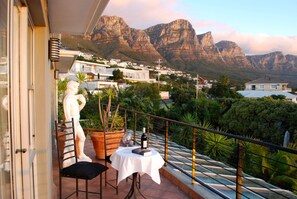 A balcony with a table, chairs, and a statue. - Villa Surprise (Cape Town)