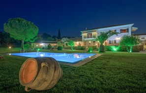 Une grande maison avec une piscine et un éclairage vert.