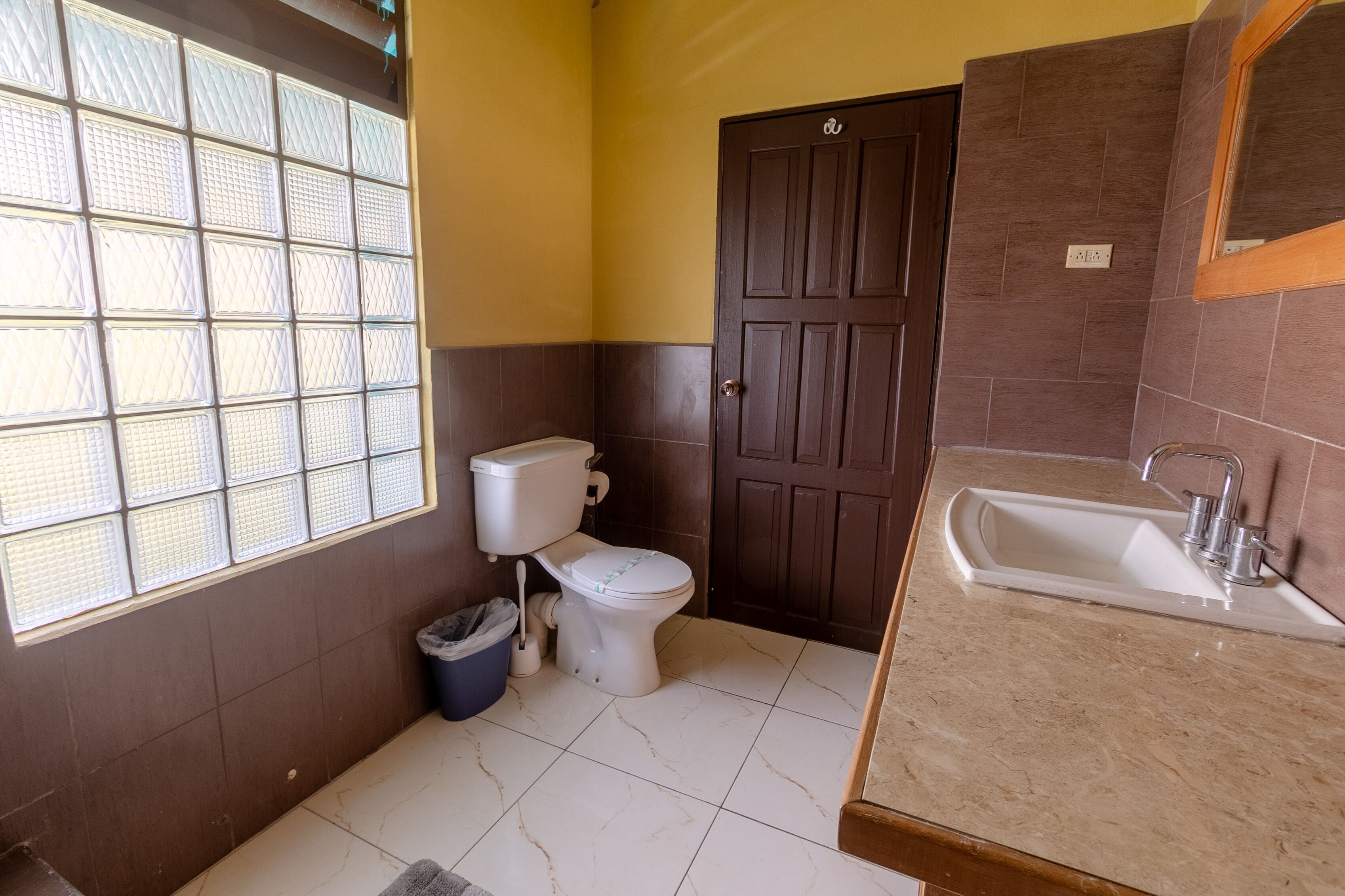 Ein Badezimmer mit Toilette, Waschbecken und Fenster.