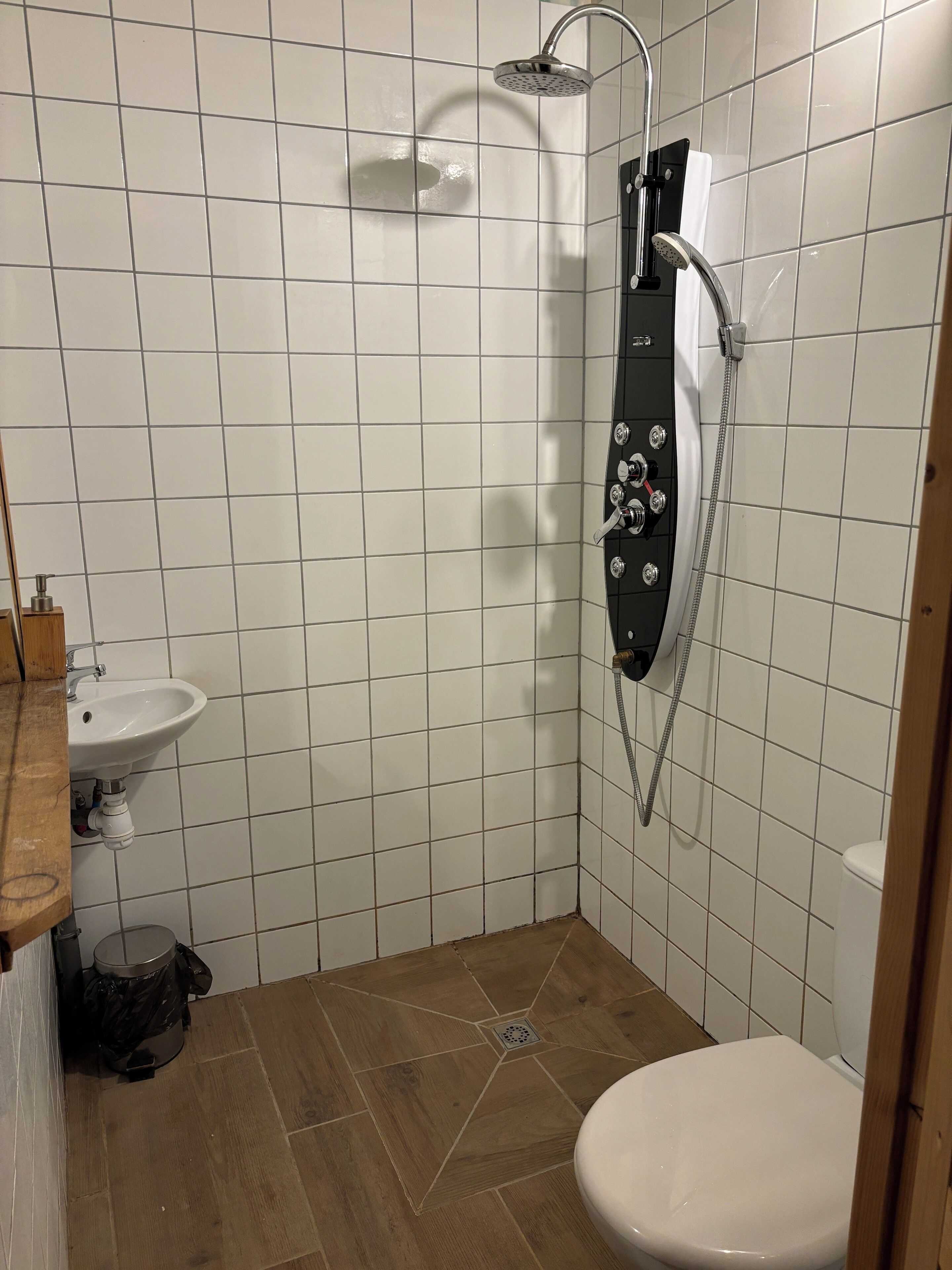 A small bathroom with a shower, toilet, and sink.