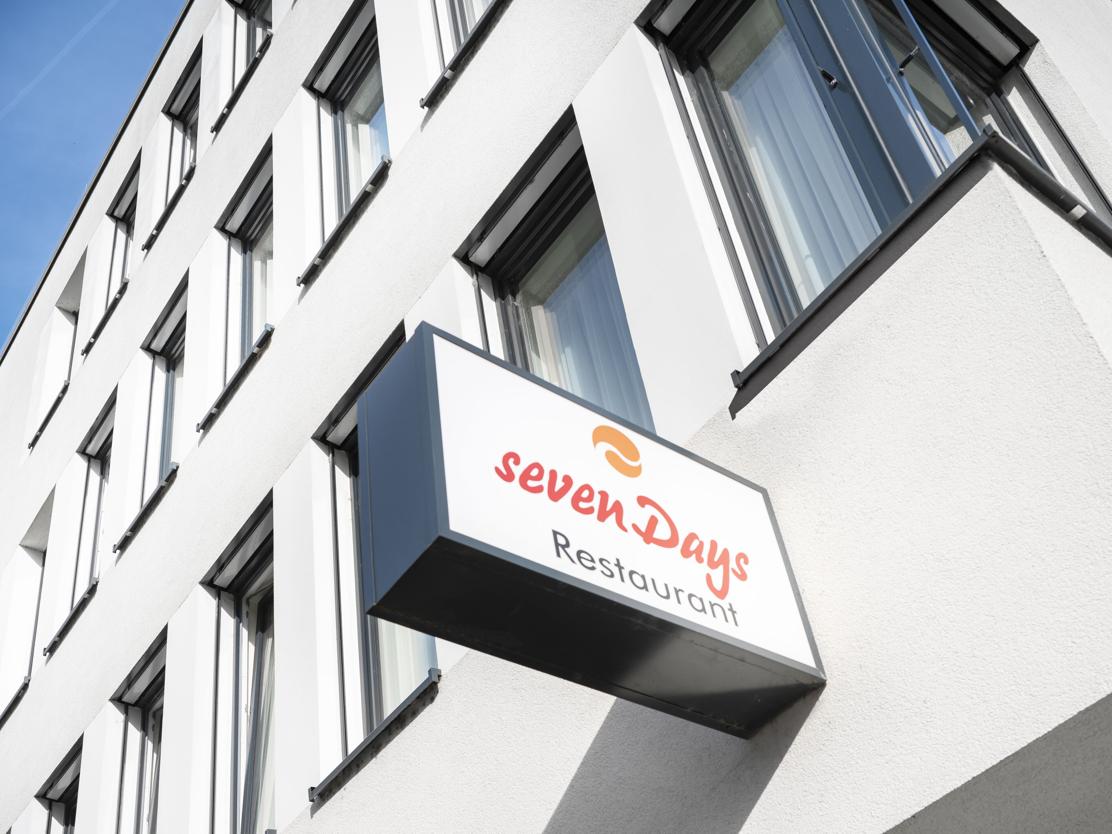 A building with a sign for 'sevenDays Restaurant'.