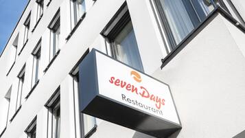 A building with a sign for 'sevenDays Restaurant'.