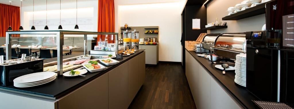 A buffet setup with various food items and a coffee station.