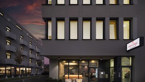 Et moderne hotel med reception, trappe og skilt der viser reception og indgang nummer 2.