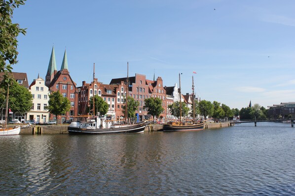 A river with boats docked, a bridge, and historic buildings with distinctive architecture.