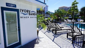 A building labeled "Ivory Sands Beach Suites" with a pool area visible in the background. - Ivory Sands Beach Suites (Clearwater Beach)