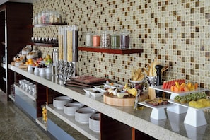 A buffet setup with various food items and utensils. - Marriott Executive Apartments Addis Ababa (Addis Ababa)