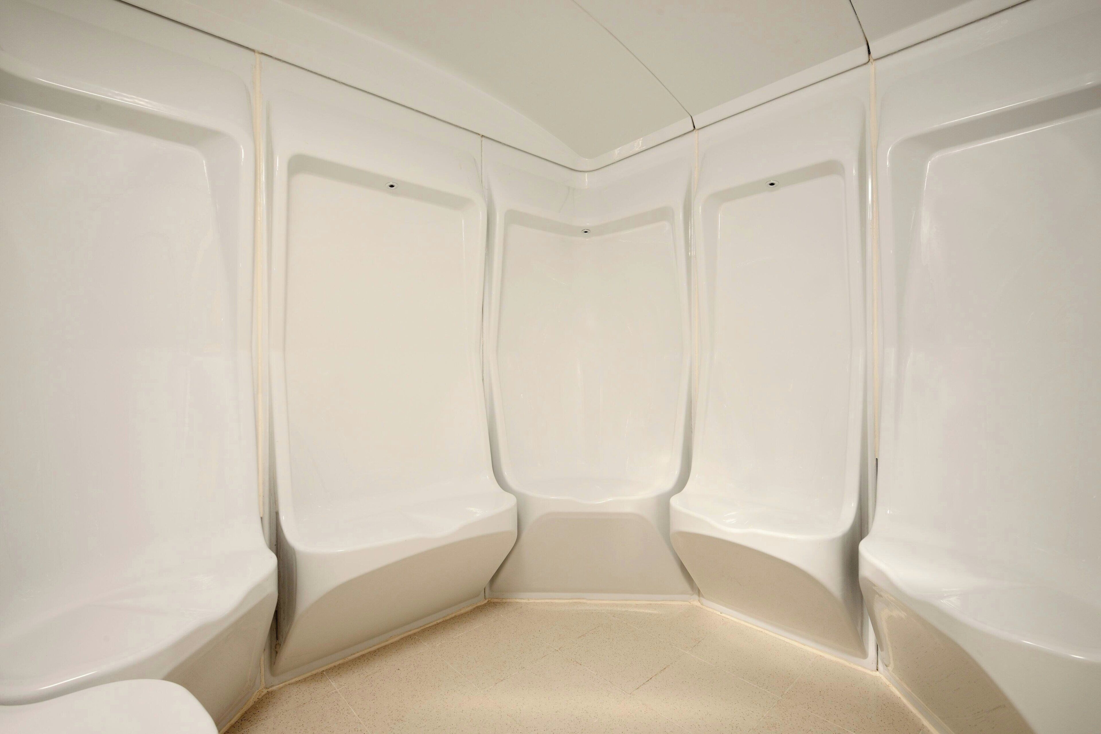 A corner of a room with white walls and a tiled floor.