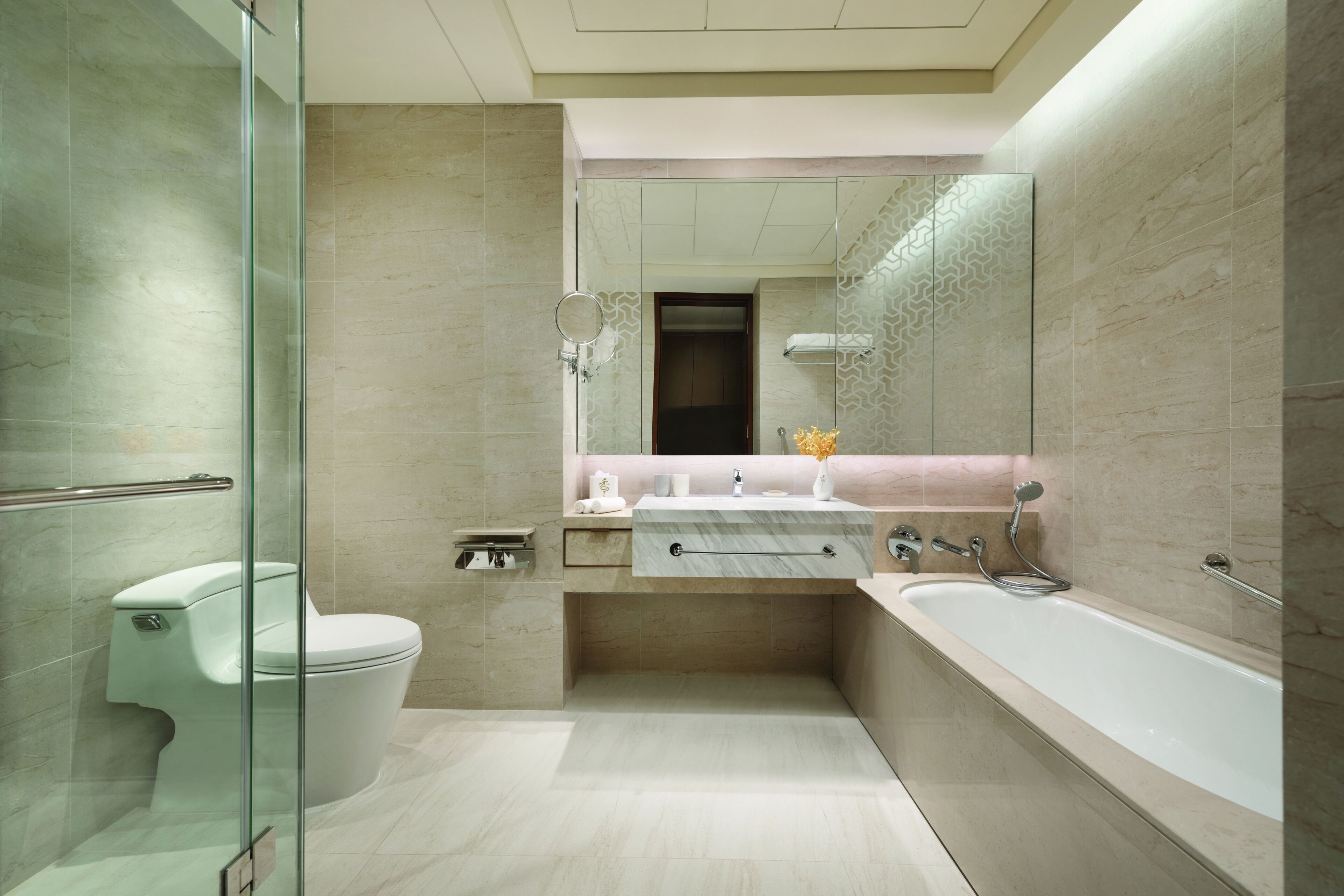 A modern bathroom with a glass shower enclosure, a toilet, a vanity with a sink, and a bathtub.