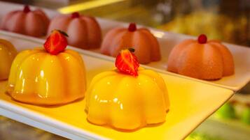 A dessert display with various shaped sweets topped with strawberries.