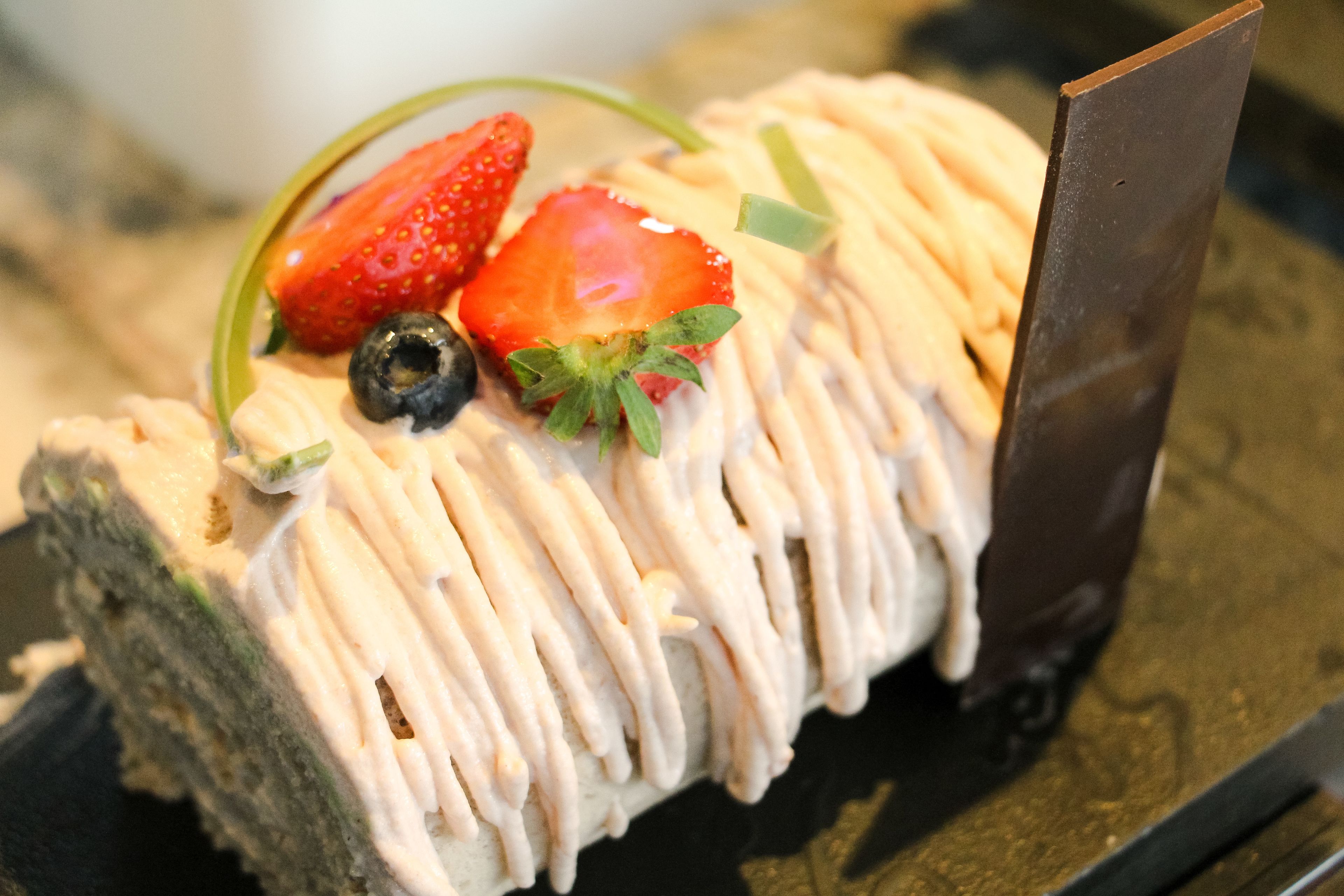 A dessert with strawberries and blueberries on top.