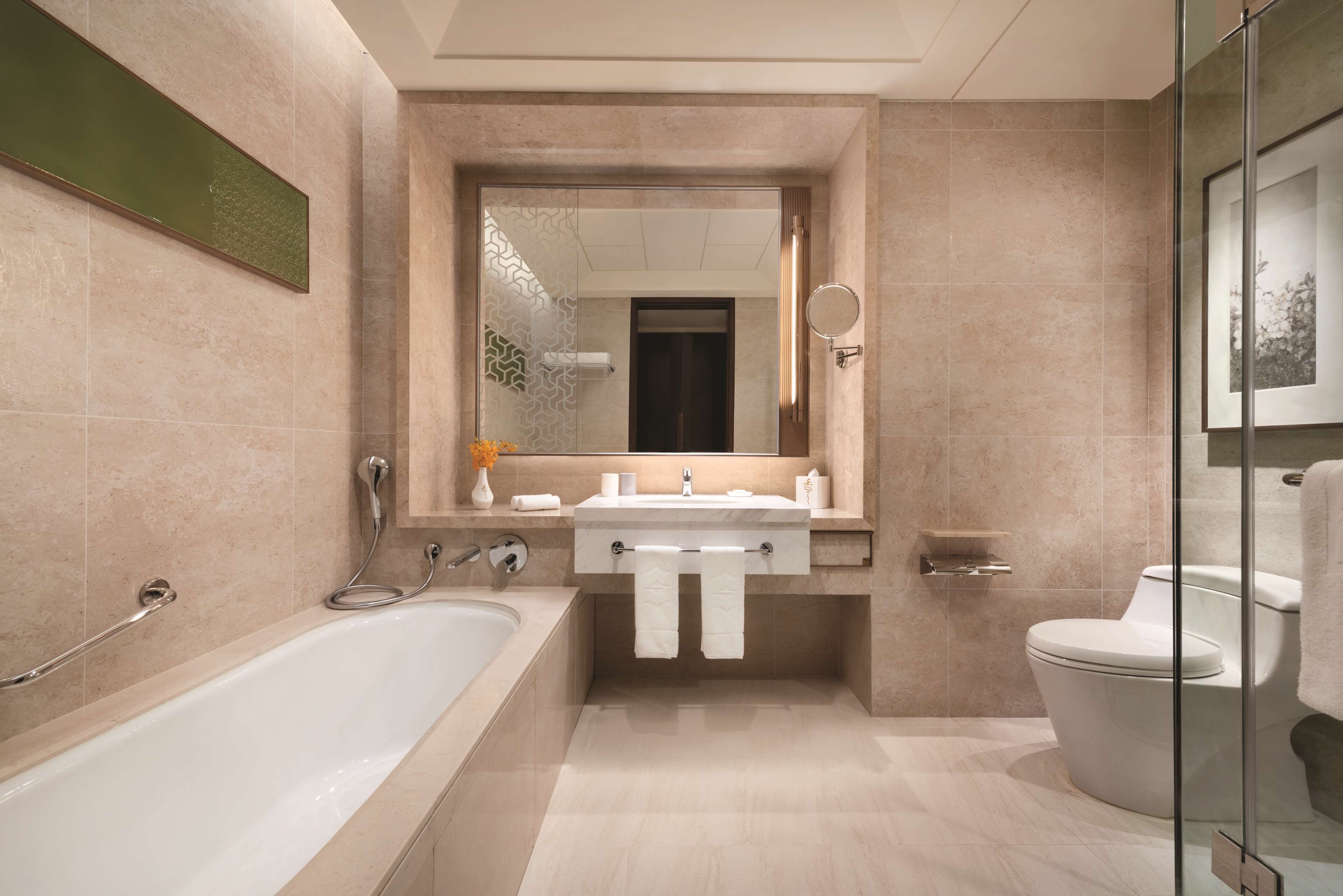 A modern bathroom with a bathtub, sink, and toilet.