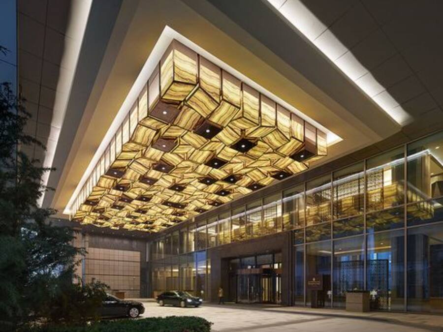 Un edificio moderno con un soffitto a motivi geometrici e ampie vetrate.