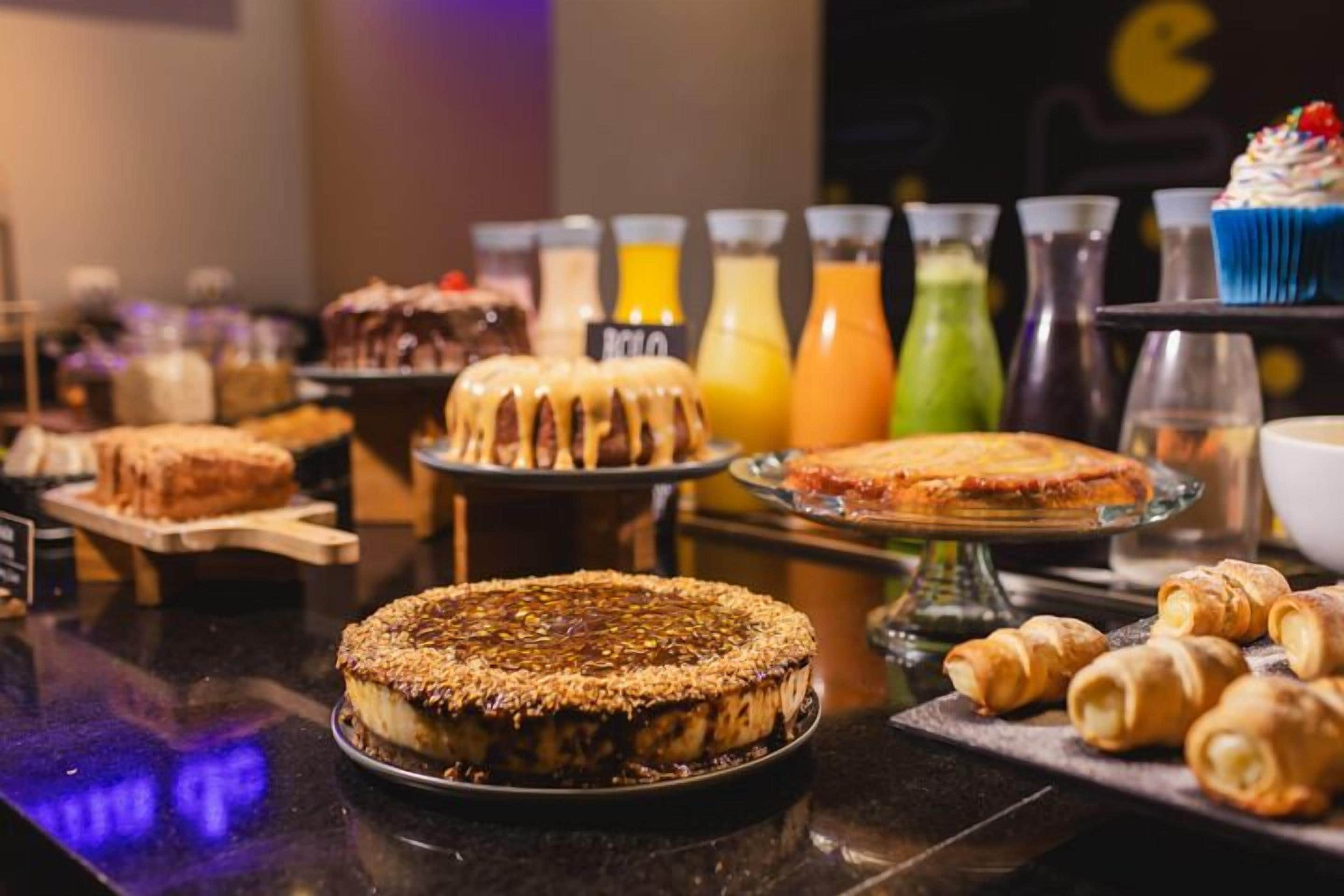 Ein Buffet mit verschiedenen Desserts, darunter Kuchen und Torten, sowie eine Auswahl an Getränken in farbenfrohen Flaschen.