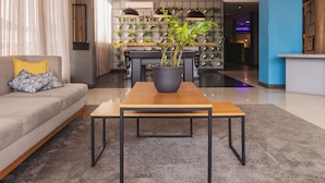 Ein modernes Wohnzimmer mit einer Couch, einem Couchtisch und einer Zimmerpflanze.