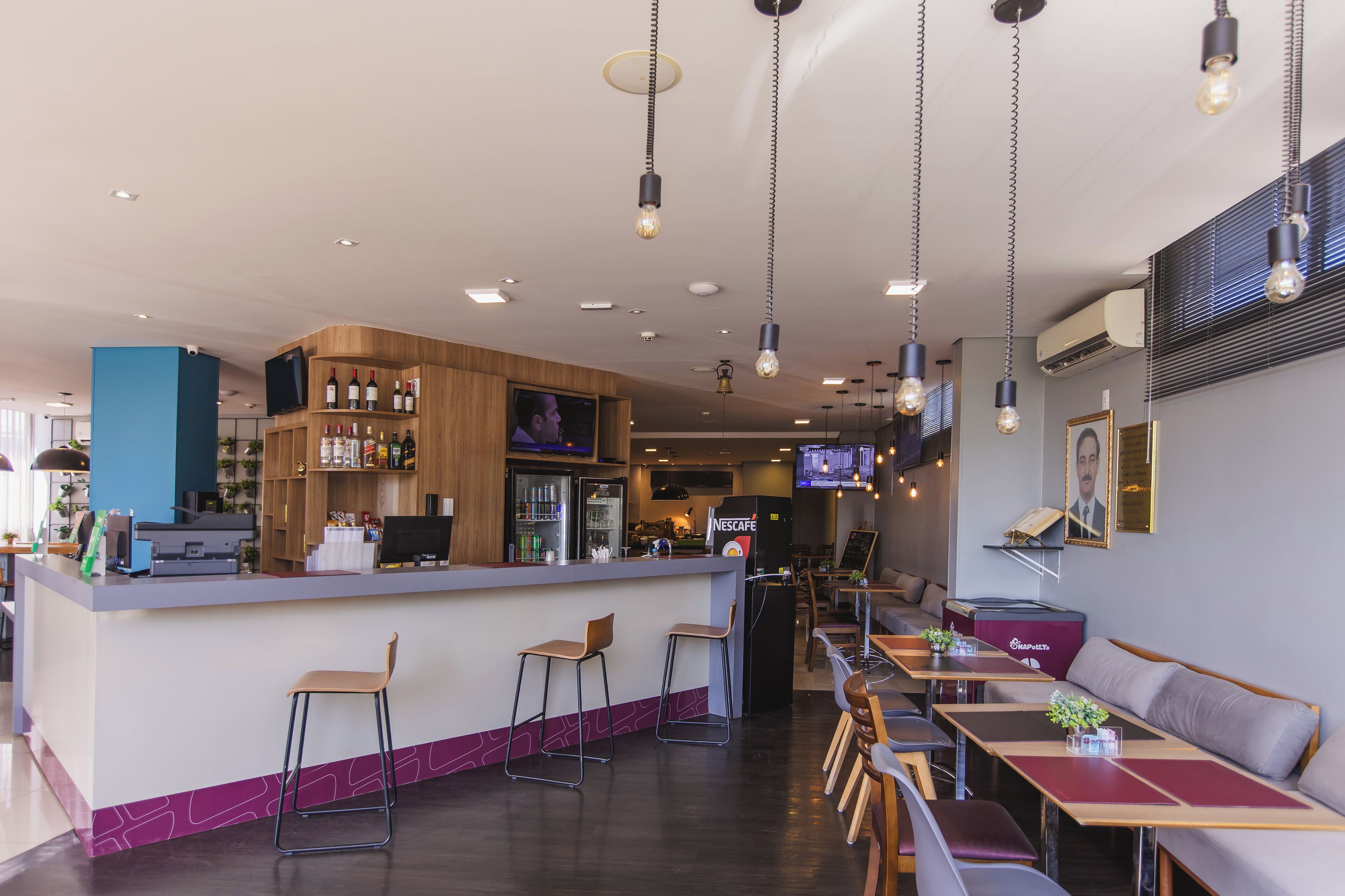 Zona de bar moderna con barra, taburetes y diferentes disposiciones de asientos.