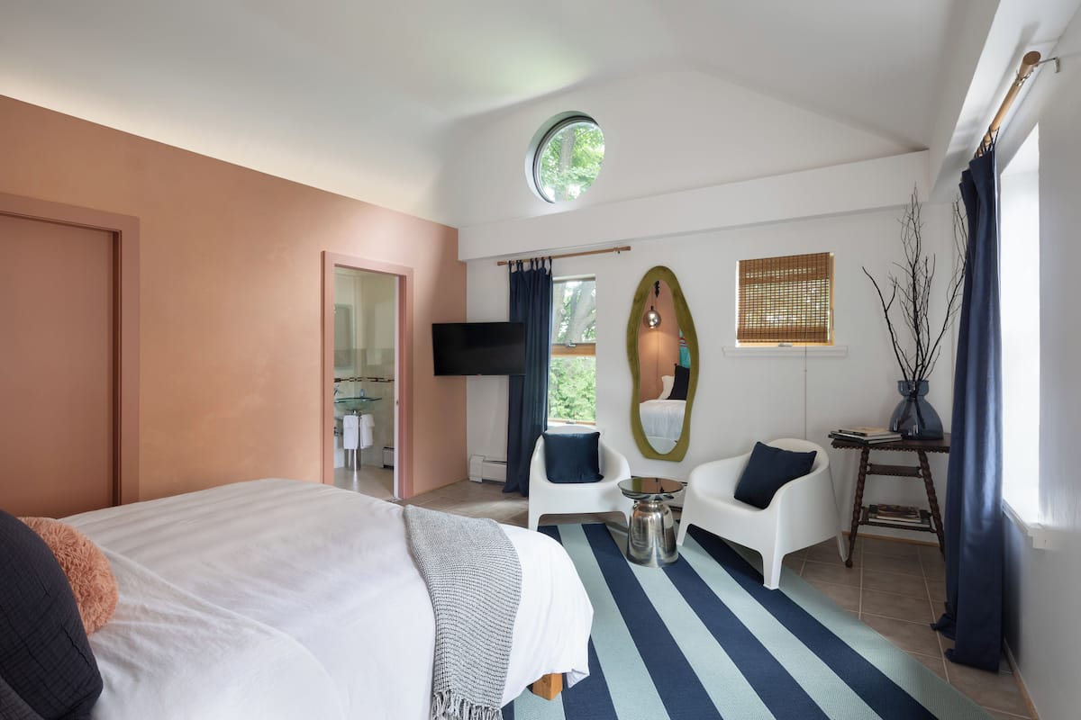 A hotel room with a bed, a TV, a desk, and a chair.