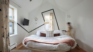 A room with a hanging bed, a white wall, a window, and a door. - The Trail in Adams - Berkshires’ Art Hotel (Adams)