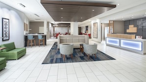 A modern hotel lobby with a reception desk, seating area, and a large sofa. - Holiday Inn Express & Suites Great Bend by IHG (Great Bend)