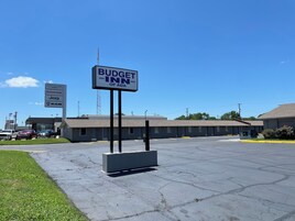 Un Budget Inn de ADA con estacionamiento y un edificio de diseño sencillo y funcional.