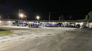 A parking lot with several trucks and a building in the background.