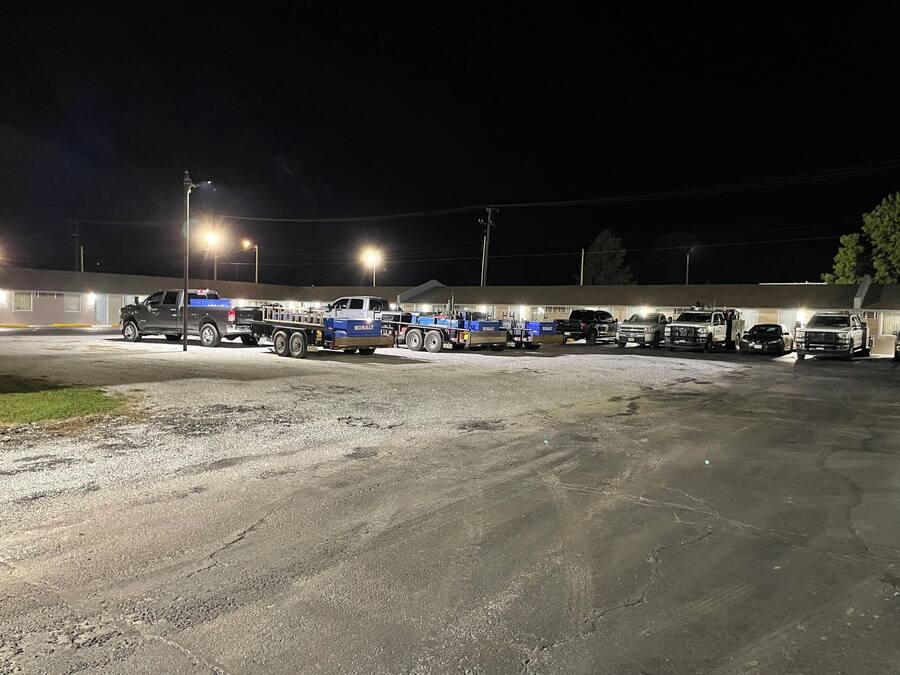 A parking lot with several trucks and a building in the background.