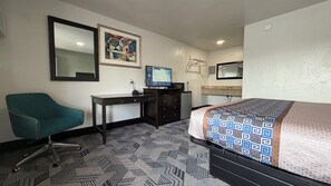A hotel room with a bed, a desk, a chair, a television, and a painting on the wall. - Budget Inn By Hotel O Ada OK (Ada)