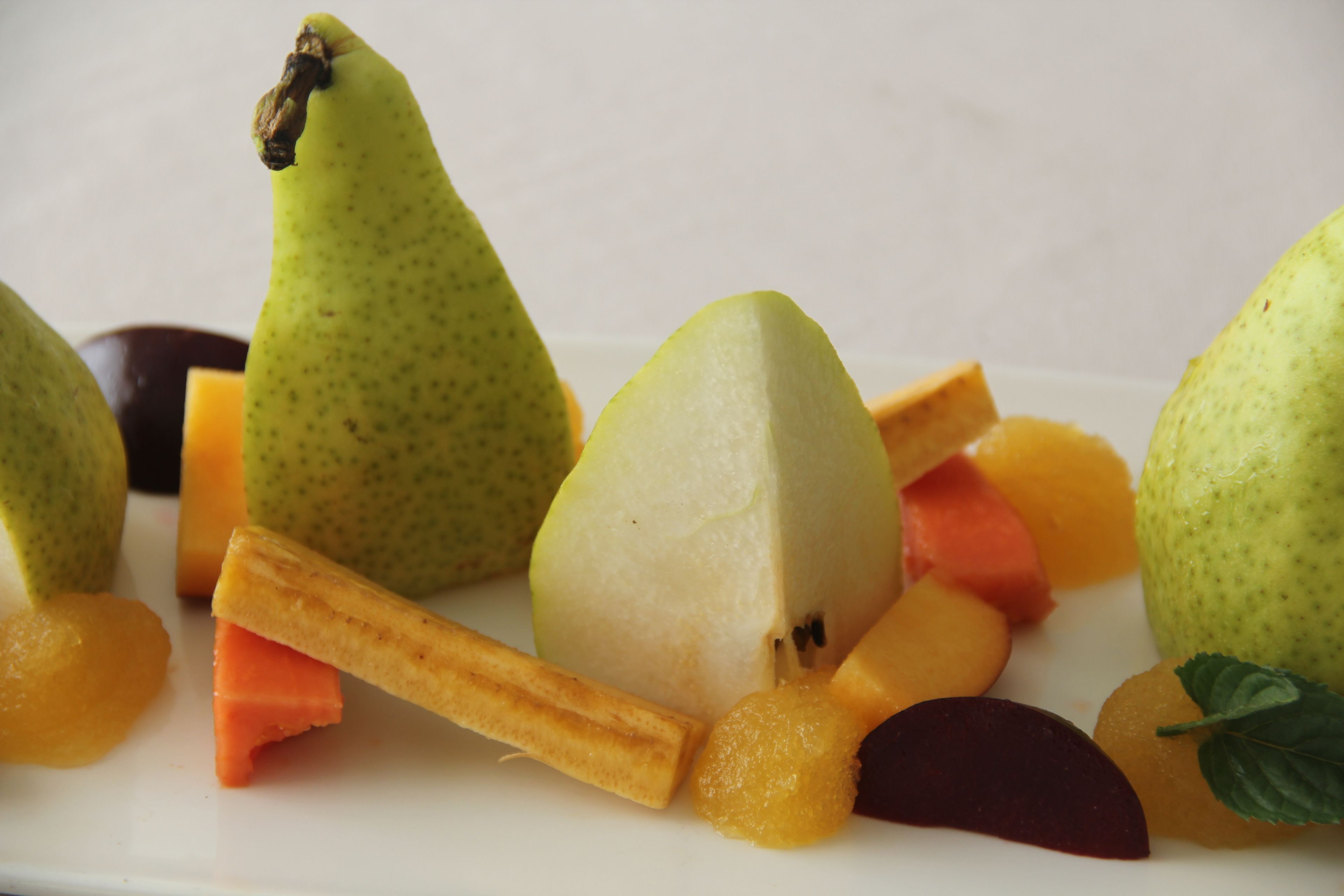 Eine Obstplatte mit Birnen, Cantaloupe und anderem Obst.