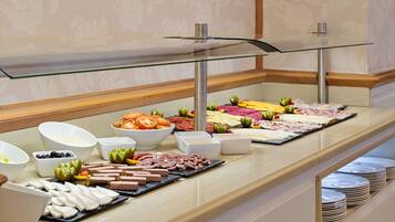 A buffet with various food items and bowls of condiments.