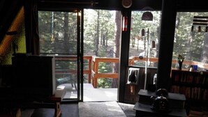 A cozy room with a stone floor, a wooden bench outside, and a fireplace. - 916 Kiowa (South Lake Tahoe)