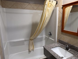 Un baño con bañera, lavamanos y espejo.