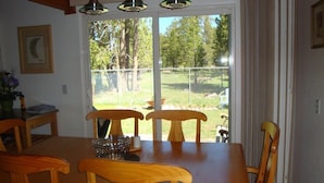 En matplats med ett träbord och stolar, en glasskål och en inramad tavla på väggen.